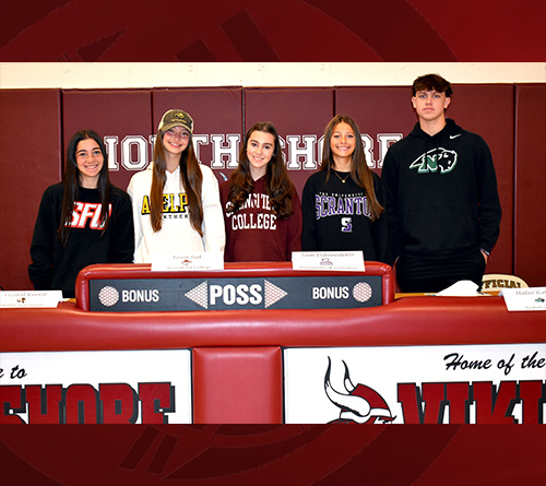 Students Standing Behind a Dais Ready to Sign