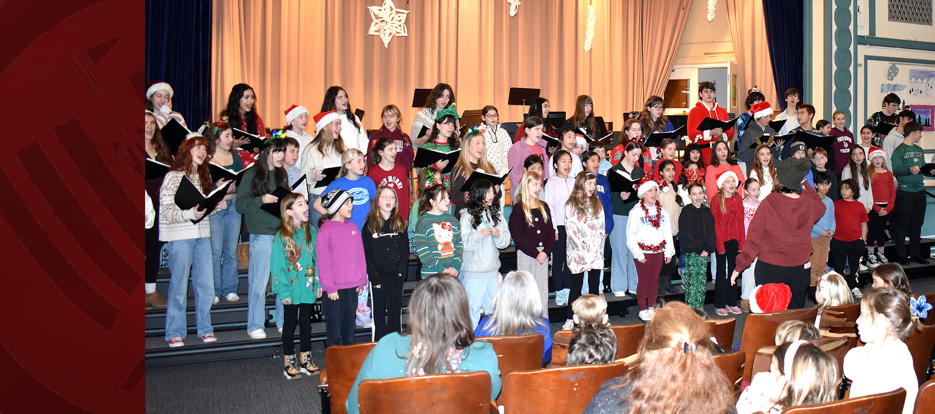 Students performing in a school holiday choir concert on stage.