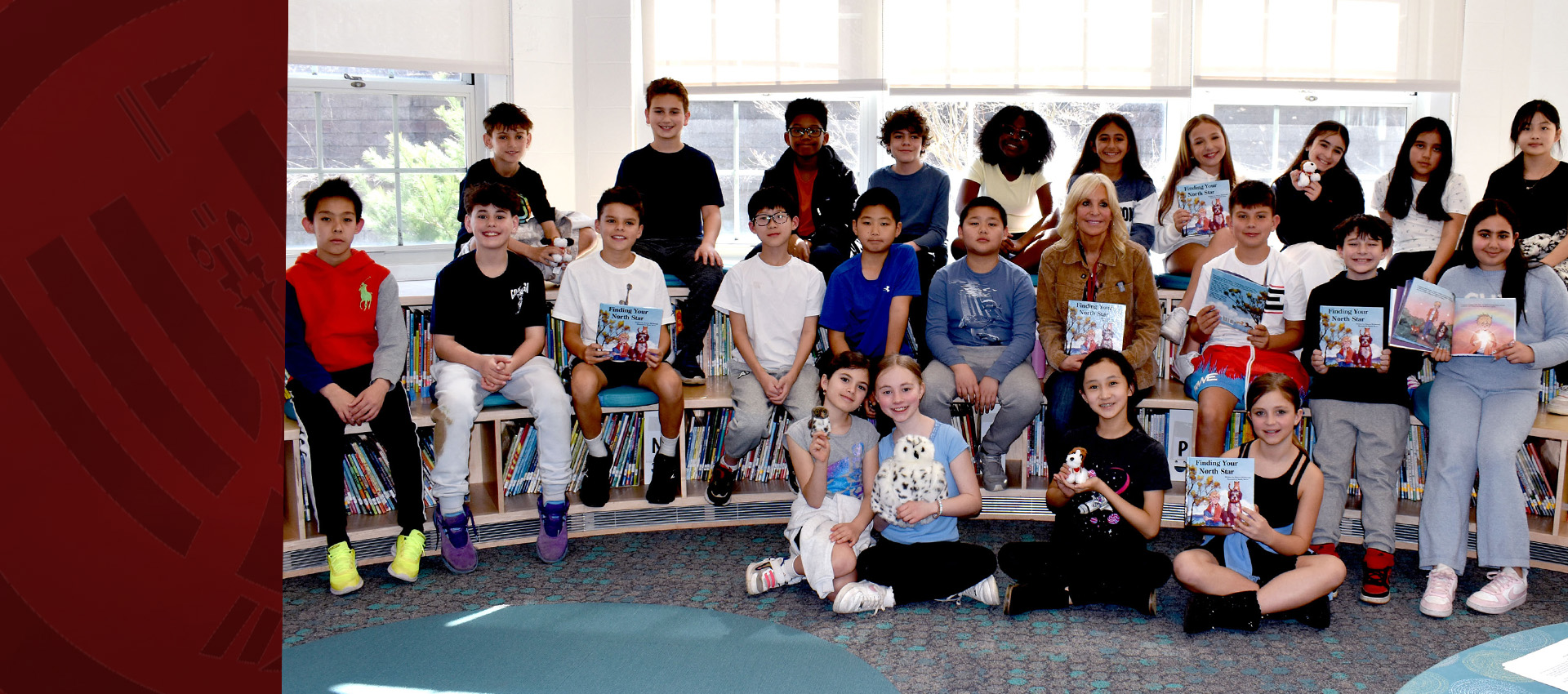 Group of elementary school students sitting together in a classroom holding books during a reading session