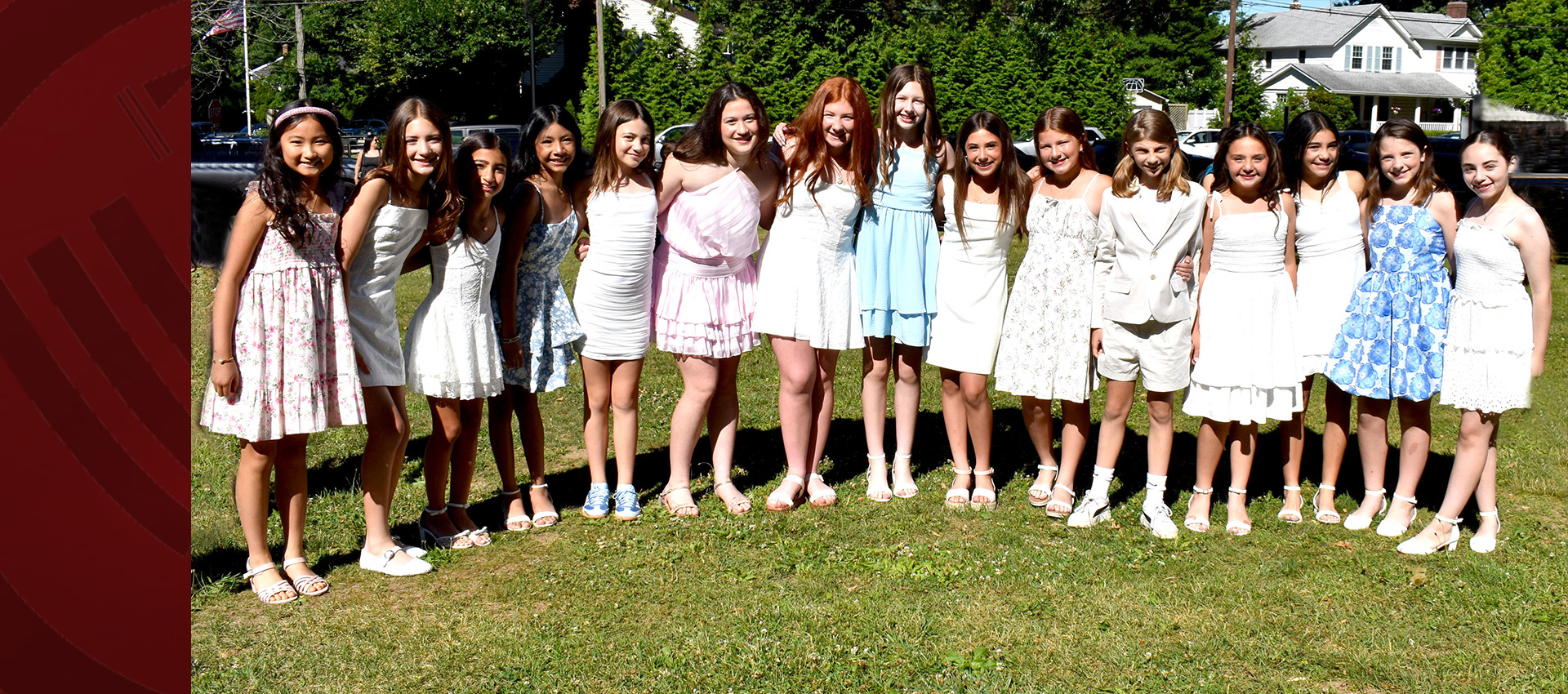Group of children standing together outdoors in formal outfits.