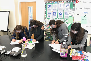 four children doing a science experiment